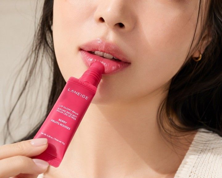 Woman wearing LANEIGE Lip Glowy Balm Berry with hydrated glossy lips